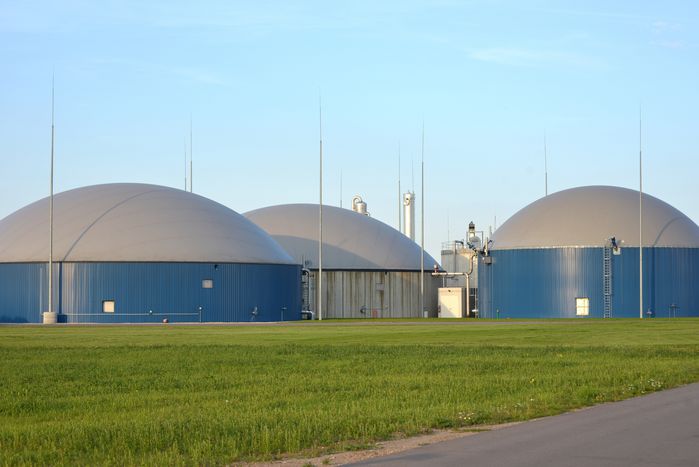 Drei runde Fermenter einer Biogasanlage im Abendlicht