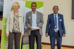 Kerstin Wilde and Dr. Solomon Tulu Tadesse present Dr. Bekele Lemma (stepping in for Dr. Mekdes Lulu) with his certificate for the Best Presentation Award.